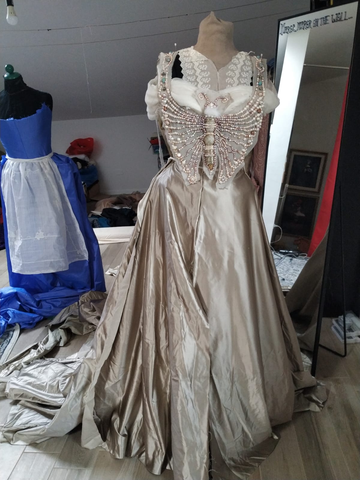 Pieces of an edwardian dress in the making, pinned on a mannequin in a costume designer's studio