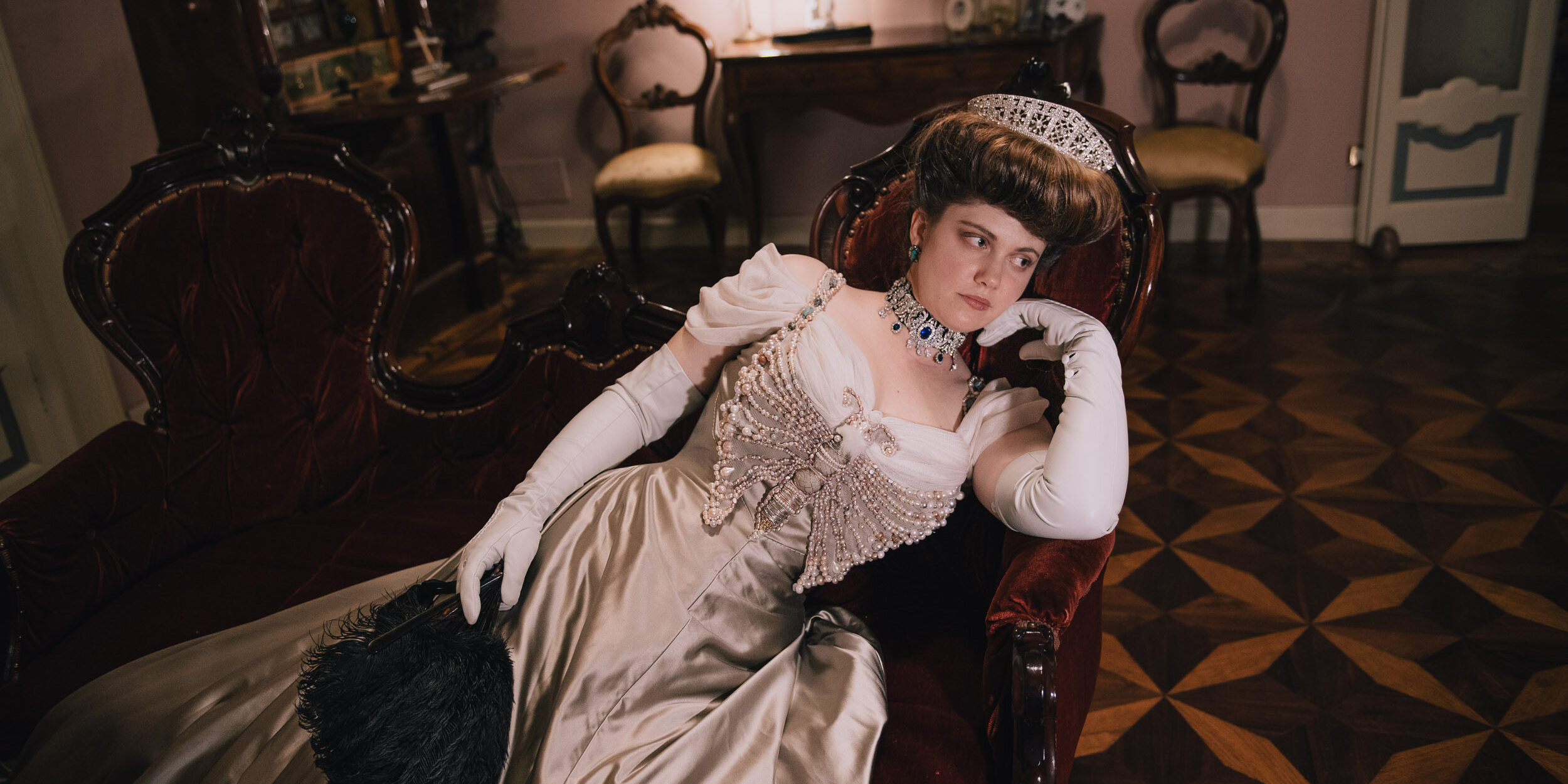 Grimilde Malatesta in Palazzo Facchi during a Historical Reverie event, photographed by Agnese Morganti. She's wearing her pearl butterfly edwardian dress, while leaning on a sofa.
