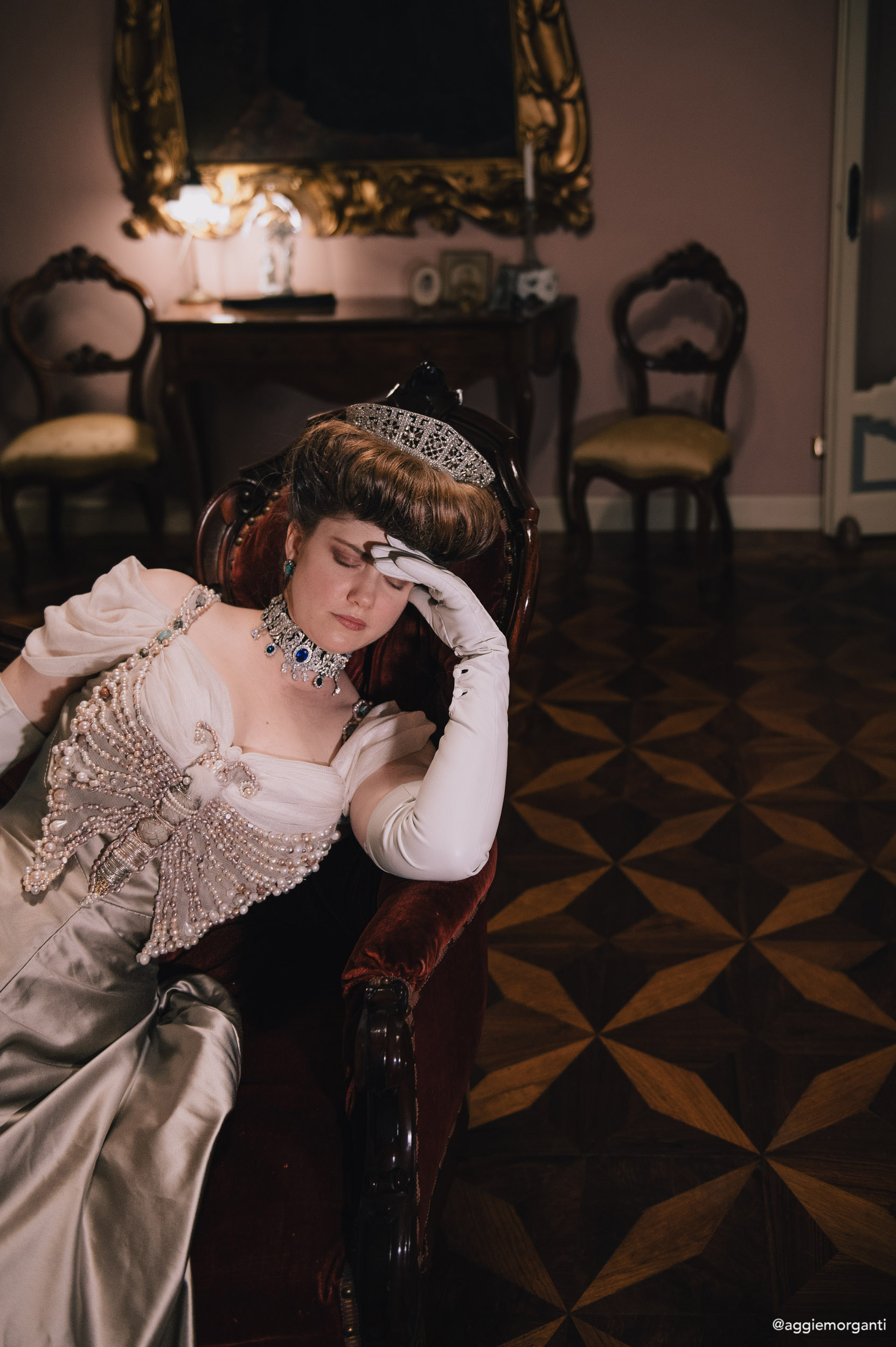 Grimilde Malatesta in Palazzo Facchi during a Historical Reverie event, photographed by Agnese Morganti. She's wearing her pearl butterfly edwardian dress, while leaning on a sofa.