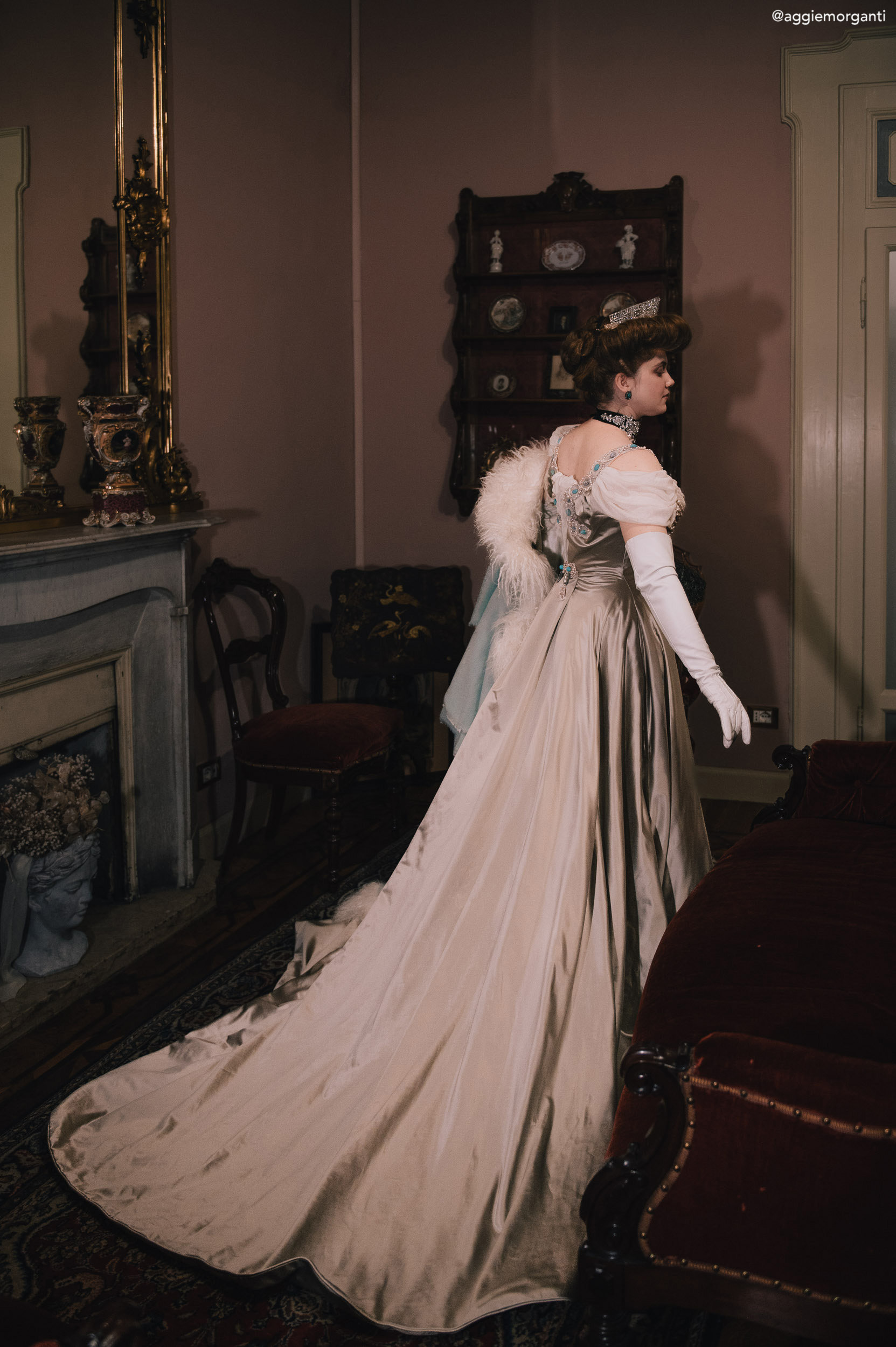 pearl butterfly dress worn by Grimilde Malatesta in a palazzo. She's turned against the camera, to show the length of the train. Photo by Agnese Morganti